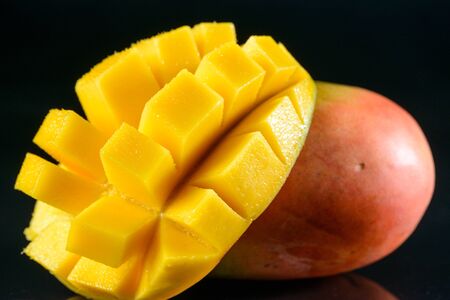 Juicy fragrant mango on glass black backgroundの写真素材