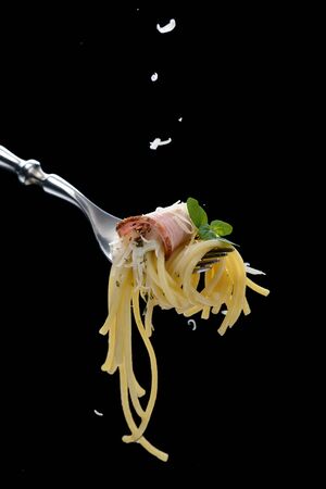 Spaghetti with bacon on forkの写真素材