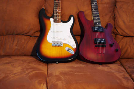Two electric guitars on the couch. Focus on the guitar body.の写真素材