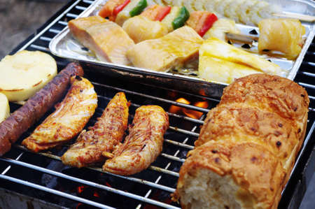 Poultry, fish, bread and sausage on the barbecue grill.の写真素材