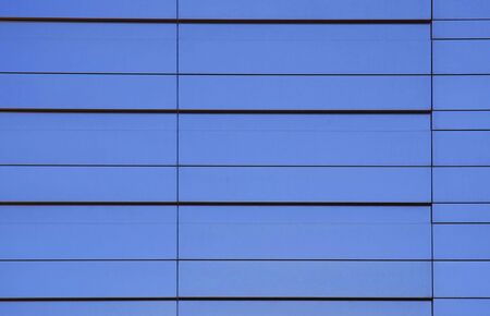 Wall of modern office building and sky reflectionの写真素材