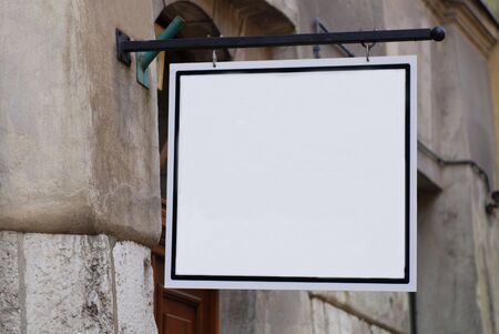 old building, white sign henging on a wall の写真素材