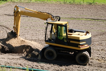 Excavator Loader standing in sandpit with pulled down bucket 