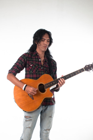 Long hair guy playing guitar acousticの写真素材