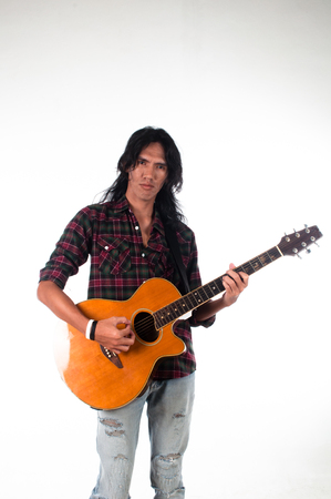 Long hair guy playing guitar acousticの写真素材