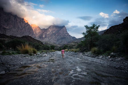 Jabal Shams, Oman, December 29, 2019: Young tourist admiring the mountains at sunset