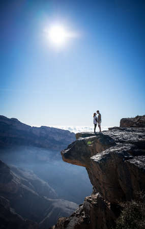 Jabal Shams, Oman, December 30, 2019: Couple looking in love on the edge of the mountain during sunriseのeditorial素材