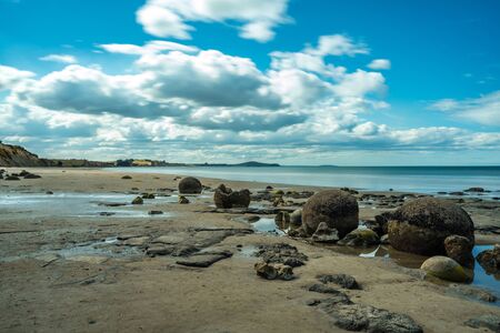 Beautiful panoramic view of Moeraki Boulders beach taken on a cloudy day, New Zealandの写真素材