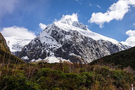 Stunning image of a snowy mountain on the SH94 road to Milford Sound taken on a sunny winter day, New Zealandの写真素材