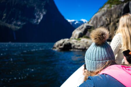 Milford Sound, New Zealand, October 5, 2019: Gorgeous image of a blonde girl with skullcap on her...