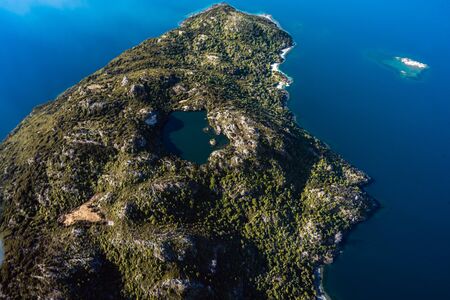 Stunning aerial image of the Arethusa Pool within Mou Waho island on Lake Wanaka taken on a sunny winter day, New Zealandの写真素材
