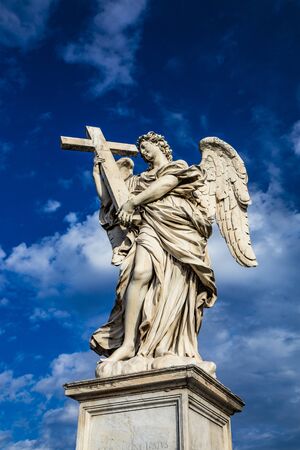Angel with the cross on the Ponte Sant'Angelo over the Tiber, at the Mausoleum of Roman Emperor Hadrian, usually known as Castel Sant'Angelo, in Rome, near the Vatican. Italyの写真素材
