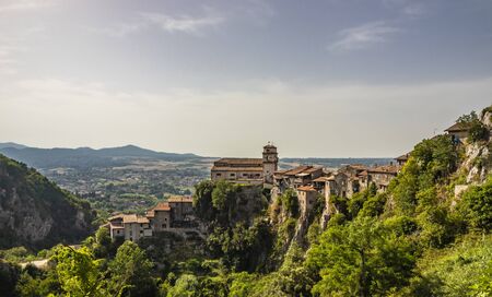 View of the valley of the Sacco River, from the ancient village of Artena. The town perched on the mountain. At the top of the cliff, the Church of Santa Croce. Trees and dense vegetation. At sunset.の写真素材