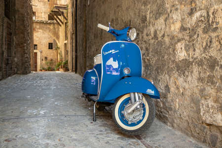 June 30, 2019 - Rome, Lazio, Italy - A blue Piaggio Vespa Sprint, parked in an alleyway of an ancient village, in Italy. The scooter symbol of Italian design.のeditorial素材