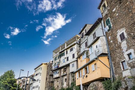 A view of the city of Zagarolo, with the houses built on the rock, overlooking a tuff hill. The contrast between the old brick houses and the new plastered and painted houses. Province of Rome, Lazioの写真素材