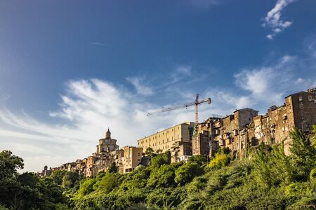 A view of the city of Zagarolo, with the houses built sheer above a tuff hill. Above the roofs, the...