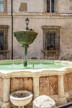 Narni, Umbria, Italy - A large fountain in the center of the village of Narni. The old brick town hall building. Blue sky in the summer.の写真素材
