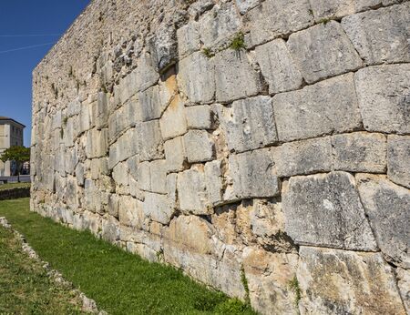 The ancient megalithic walls surround the acropolis of Amelia, in Umbria, Italy. Texture composed of huge blocks of stone, with irregular boulders interlocked together.の写真素材