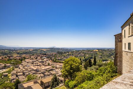 The ancient and beautiful city of Amelia, in Umbria, seen from above. The view of the green Umbrian hills. The mountains in the background. The rich vegetation, the streets and the roofs of the housesの写真素材