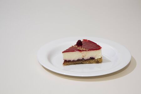 a slice of cheesecake on a white plate. Isolated on white background.の写真素材