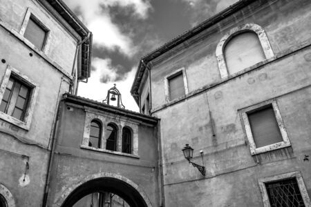 A view of Piazza Dante. Ancient building with arch, three windows and bell. Anagni, Frosinone, Italy.の写真素材