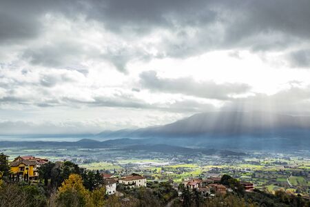 Beautiful view of the Valle del Sacco at sunset, from Anagni, Frosinone, Italy. Rays of light in the clouds, the mountains and the green valley.の写真素材