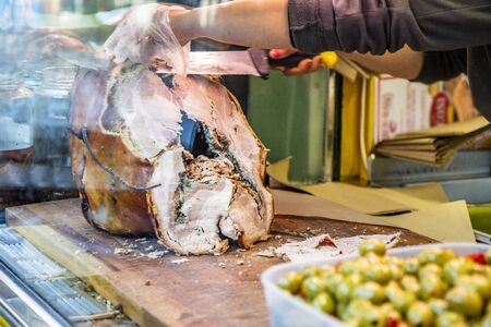 The traditional pork of Ariccia on the counter of a street vendor (italian food). A woman slices the pork to make a sandwich. Frascati, Ariccia, Rome, Lazio, Italy, Roman Castlesの写真素材