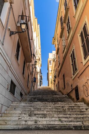 February 17, 2019 - Frascati, Rome, Lazio, Italy - A detail of Frascati, in the Roman Castles, with one of its historic buildings and one of its many stairways. Glimpse of blue sky between the buildings.の写真素材