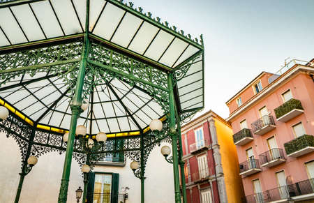 October 27, 2019 - Isernia, Molise, Italy - The Art Nouveau green wrought iron gazebo. The matt satined glass cover and floral decorations. The windows of the houses with balconies overlook the squareのeditorial素材