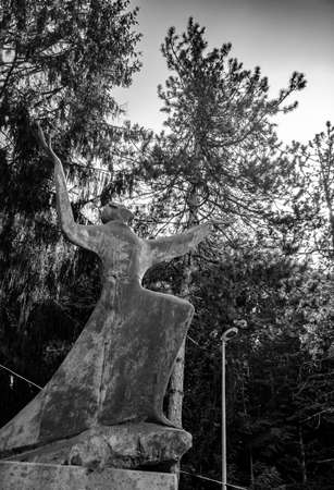 October 6, 2019 - Bellegra, Lazio, Italy - Convent of San Francesco. The statue of a holy friar, in adoration and contemplation of God. Arms and hands extended towards the blue sky. Glare of the sun.のeditorial素材
