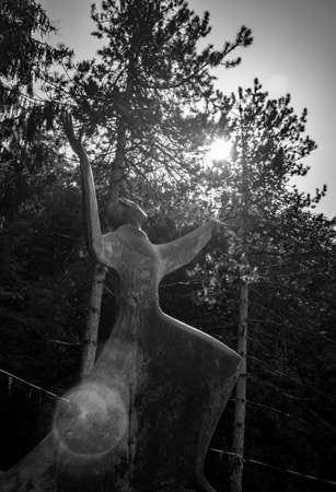 October 6, 2019 - Bellegra, Lazio, Italy - Convent of San Francesco. The statue of a holy friar, in adoration and contemplation of God. Arms and hands extended towards the blue sky. Glare of the sun.のeditorial素材