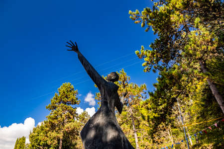 October 6, 2019 - Bellegra, Lazio, Italy - Convent of San Francesco. The statue of a holy friar, in adoration and contemplation of God. Arms and hands extended towards the blue sky.のeditorial素材