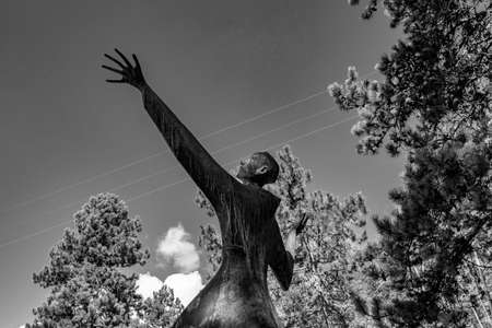 October 6, 2019 - Bellegra, Lazio, Italy - Convent of San Francesco. The statue of a holy friar, in adoration and contemplation of God. Arms and hands extended towards the blue sky.のeditorial素材