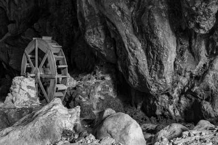 October 6, 2019 - Bellegra, Rome, Lazio, Italy - The karst caves, called "Grotte dell'Arco" (Caves of the Arc). The wheel of an old mill, now in disuse. The rocky wall of the cave.のeditorial素材