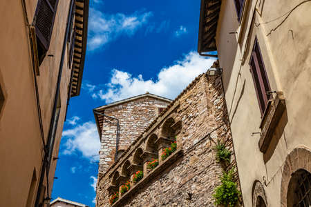 June 1, 2019 - Spello, Perugia, Umbria, Italy - A characteristic alley of the medieval village, with stone and brick houses, plants and flowers on the balconies.のeditorial素材