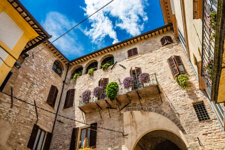 June 1, 2019 - Spello, Perugia, Umbria, Italy - A characteristic alley of the medieval village, with stone and brick houses, plants and flowers on the balconies.のeditorial素材