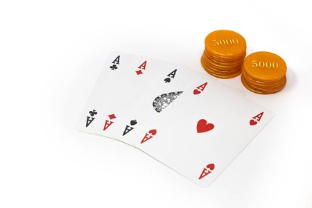 Stack of chips, isolated on white background. Colors: ivory, orange, blue, green, red. Betting, winning and losing at gambling. Play with poker cards and fiches. Poker of aces.の写真素材