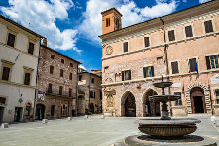 June 1, 2019 - Spello, Perugia, Umbria, Italy - The town hall of Spello with the Italian and European flag (EEC). The tower with the clock. Fountain.のeditorial素材