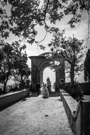 October 14, 2018 - Ravello, Campania, Italy - Two young newlyweds in love, do the photo shoot in Villa Cimbrone, on the Amalfi coast. Just married, in autumn with the leaves falling in the wind.のeditorial素材