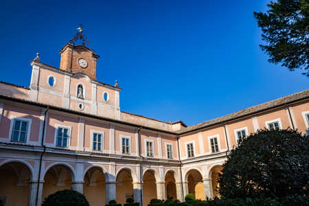 March 24, 2019 - Collepardo, Frosinone, Lazio, Italy - Trisulti Charterhouse, Carthusian monastery. The courtyard of the abbey, with the porch, the windows, the clock and the garden. Clear blue sky.のeditorial素材