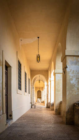 March 24, 2019 - Collepardo, Frosinone, Lazio, Italy - Trisulti Charterhouse. A long corridor under an arcade, with the light passing through the arches and columns. Cross vault.のeditorial素材