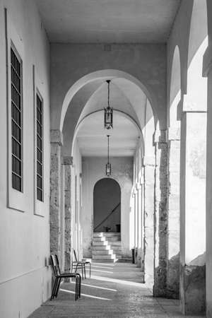 March 24, 2019 - Collepardo, Frosinone, Lazio, Italy - Trisulti Charterhouse. A long corridor under an arcade, with the light passing through the arches and columns. Cross vault.のeditorial素材