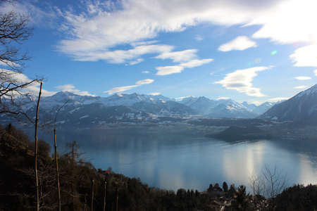 View of the lake, among the snow-capped mountains, in winter. Lake Thun is a lake in the canton of Bern in Switzerland, in the city of Thun. It is a natural lake formed by the river Aare.の写真素材