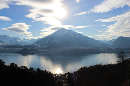 View of the lake, among the snow-capped mountains, in winter. Lake Thun is a lake in the canton of Bern in Switzerland, in the city of Thun. It is a natural lake formed by the river Aare.の素材 [FY310153074854]