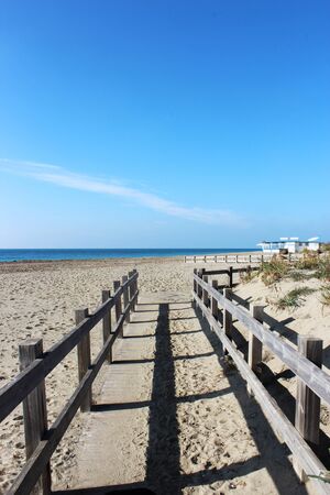 the deserted sea in winter with rough seas, seaweed on the shore and debris on the sand of the beach. A closed bathhouse.の写真素材