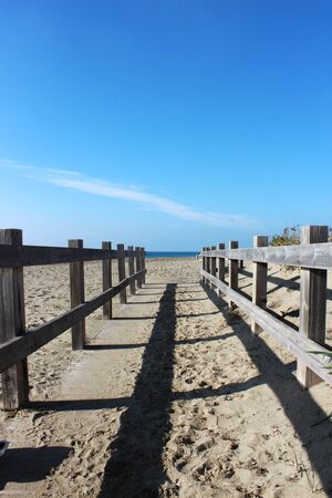 the deserted sea in winter with rough seas, seaweed on the shore and debris on the sand of the beach. A closed bathhouse.の写真素材
