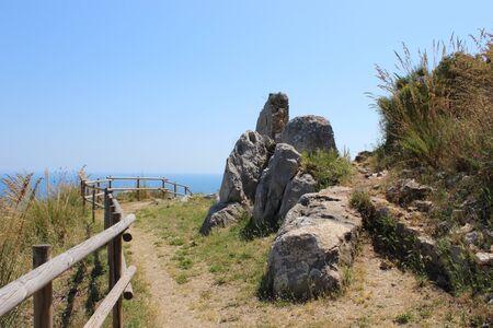 The Temple of Jupiter, Mount Circeo, in Terracina, Lazio, Italy. The remains of the temple on the top of the mountain and the view of the city and the sea from above. The blue sky on summer day.の写真素材
