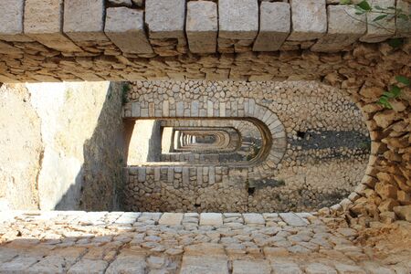 The Temple of Jupiter, Mount Circeo, in Terracina, Lazio, Italy. The remains of the temple on the top of the mountain. A series of consecutive arches and columns create a tunnel.の写真素材