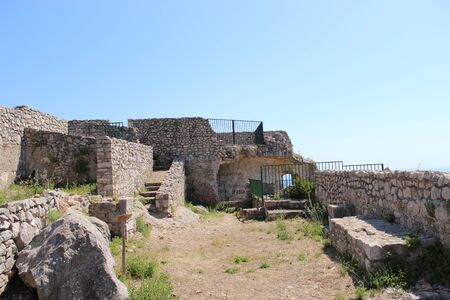 The Temple of Jupiter, Mount Circeo, in Terracina, Lazio, Italy. The remains of the temple on the top of the mountain and the view of the city and the sea from above. The blue sky on summer day.の写真素材