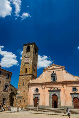June 28, 2020 - Civita di Bagnoregio, Viterbo, Tuscia, Lazio, Italy - The Church of San Donato with the bell tower and the clock. Three wooden doors.のeditorial素材